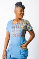 blouse médicale caribéenne bleue pour femme avec empiècements en madras roue brique, jaune moutarde et bleu -uniforme pofessionnel élégant et moderne twopikal wear