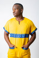 tunique médical homme jaune avec détails ethniques bleus, tenue professionnelle élégante twopikal wear , uniforme coloré caribéen infirmier ou aide soignante.