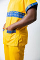 tunique médical homme jaune avec détails ethniques bleus, tenue professionnelle élégante twopikal wear , uniforme coloré caribéen infirmier ou aide soignante muni de jolies poches.