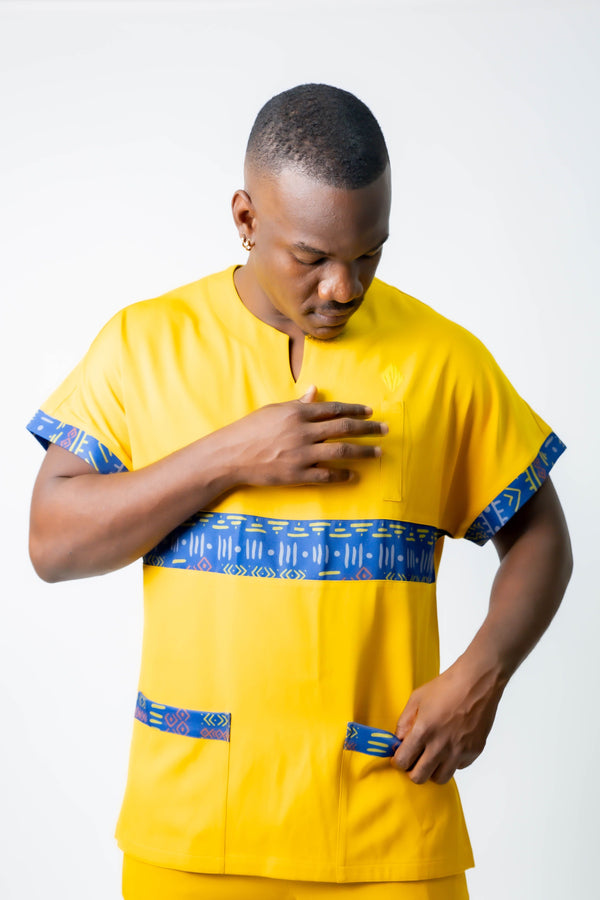 tunique médical homme jaune avec détails ethniques bleus, tenue professionnelle élégante twopikal wear , uniforme coloré caribéen infirmier ou aide soignante.