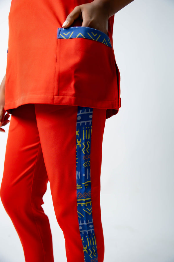 tunique médical femme rouge avec détails ethniques bleus, tenue professionnelle élégante twopikal wear , uniforme coloré caribéen infirmière ou aide soignante.